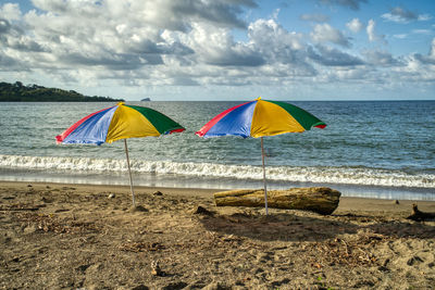 Umbrella on beach against sky