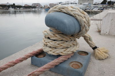 High angle view of ropes tied to cleat at harbor