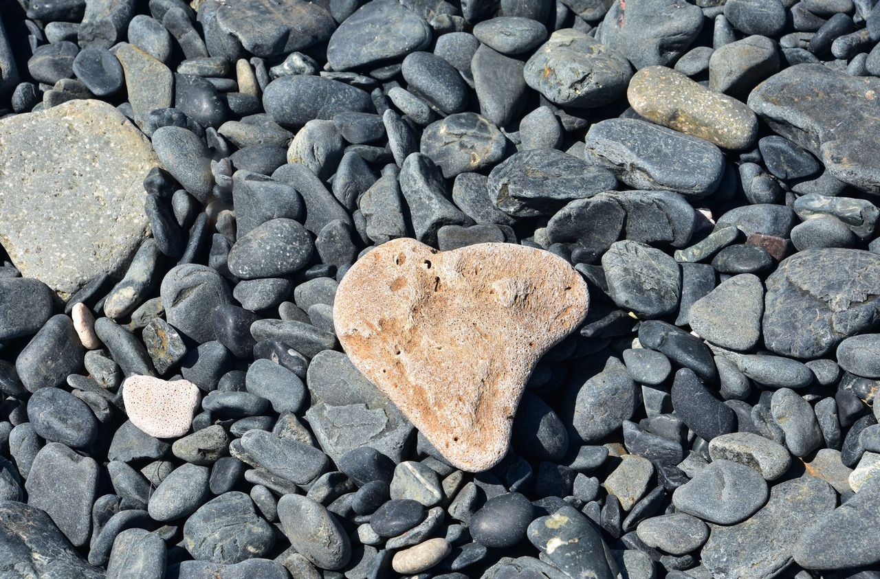 rock, heart shape, stone, soil, love, positive emotion, high angle view, no people, full frame, day, pebble, large group of objects, emotion, backgrounds, gravel, nature, textured, abundance, shape, outdoors, rubble, directly above, close-up, land, road surface, asphalt, gray, still life