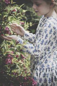 Midsection of woman holding flowering plants