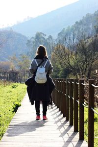 Rear view of woman walking on footpath