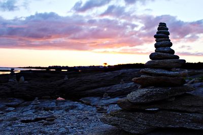 Stack of rocks against sky during sunset