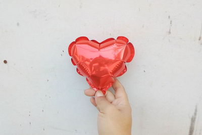 Close-up of woman holding heart shape with hands