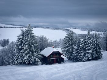 Snow covered field against sky during winter