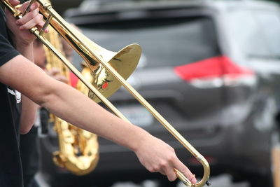 Midsection of musician playing trumpet during fourth of july parade
