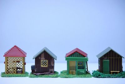 House amidst trees and buildings against clear blue sky