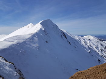 Scenic view of snowcapped mountains against blue sky