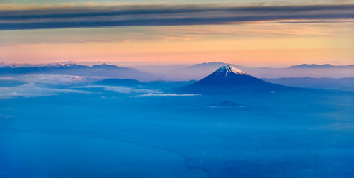 Scenic view of snowcapped mountains against sky during sunset