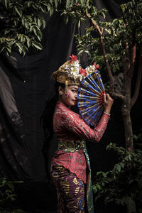 Portrait of woman wearing traditional clothing standing in forest