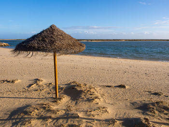 Lifeguard hut on beach against sky