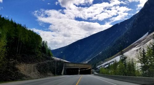 Road amidst trees against sky