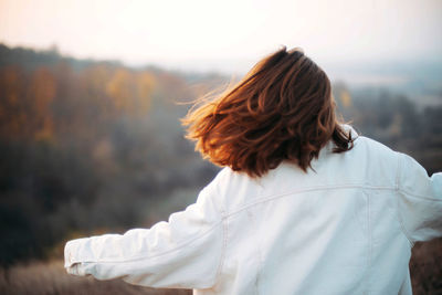 Rear view of woman standing against white background