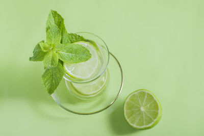 Tea with mint and lime, with a calming effect, green still life close-up on a green background, 