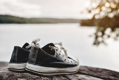 Close-up of canvas shoes on lakeshore