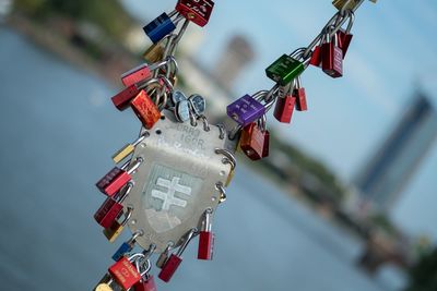 Close-up of padlocks hanging against river