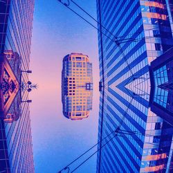 Low angle view of modern building against blue sky