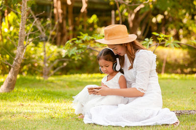 Woman wearing hat sitting on grass