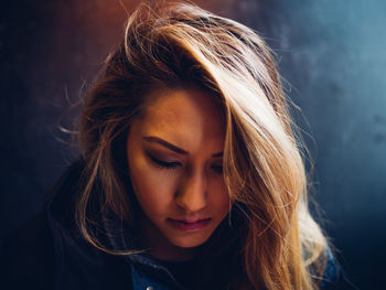 Close-up of young woman against gray background