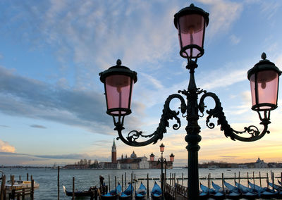 Close-up of street light at grand canal by santa maria della salute against sky