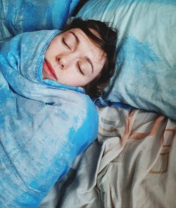 High angle view of girl sleeping on bed