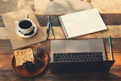 High angle view of coffee and laptop on table