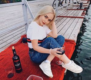 High angle view of young woman using mobile phone while sitting outdoors