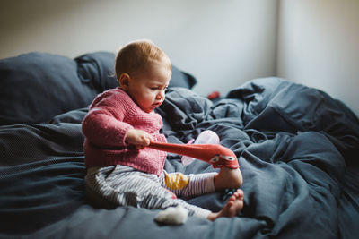 Portrait of cute baby boy lying on bed at home