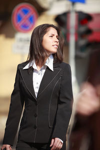 Woman looking away while standing outdoors