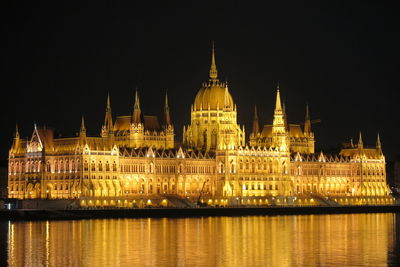 Illuminated parliament of hungary lit up at night seen from the other side of the danube