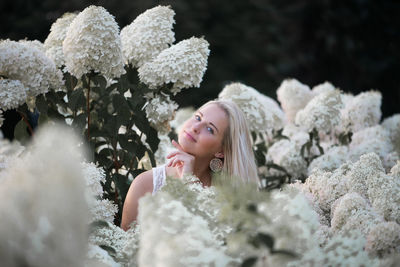 Portrait of smiling beautiful woman amidst flowers