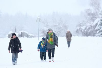 Rear view of children on field during winter