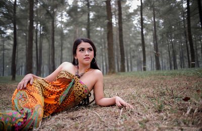 Portrait of a young woman sitting in a forest