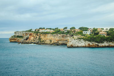 Scenic view of sea by buildings against sky