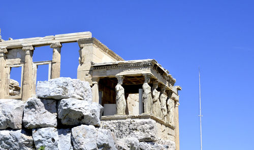 Low angle view of old building against clear blue sky