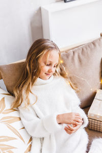 Cute girl smiling on sofa at home