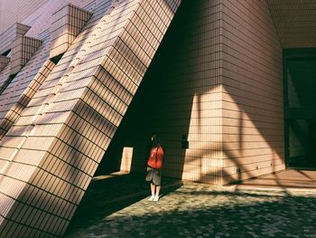 Rear view of woman standing by modern building