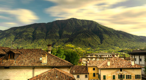 Panorama, roofs of the houses in the center of feltre and the verdant monte tomatico, belluno, italy