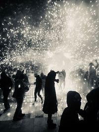 People watching firework display at night