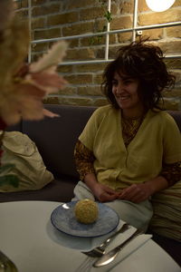 Young woman sitting in a dumplings and pastry shop in a shirt and sweater