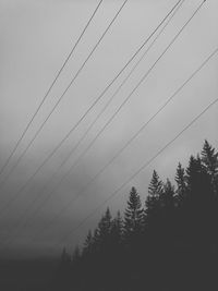 Low angle view of silhouette trees against sky