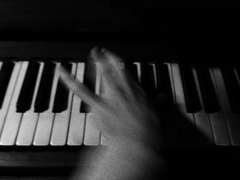 Close-up of hand playing piano