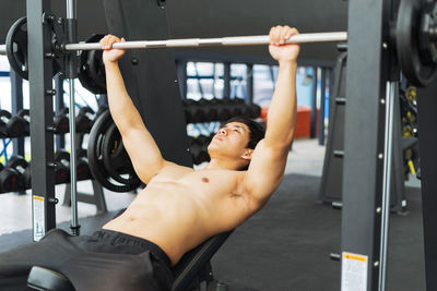 Shirtless man exercising in gym