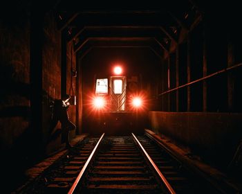 Train in illuminated railroad station at night