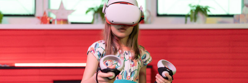 Vr game virtual reality. kid girl gamer playing on futuristic simulation video game in 3d glasses