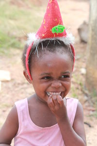 Close-up of cute girl smiling while wearing santa hat