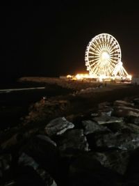 Illuminated ferris wheel at night