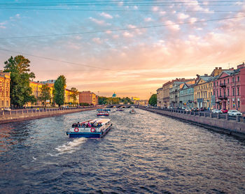 Bridge over river in city at sunset