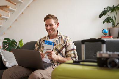 Portrait of young man using laptop while sitting at home