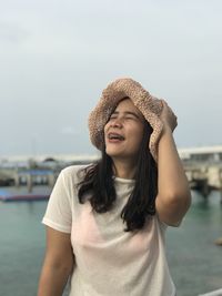 Young woman wearing hat standing against sky