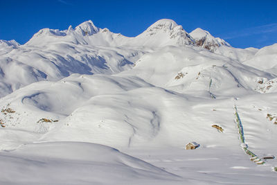 Scenic view of snow mountains against clear blue sky